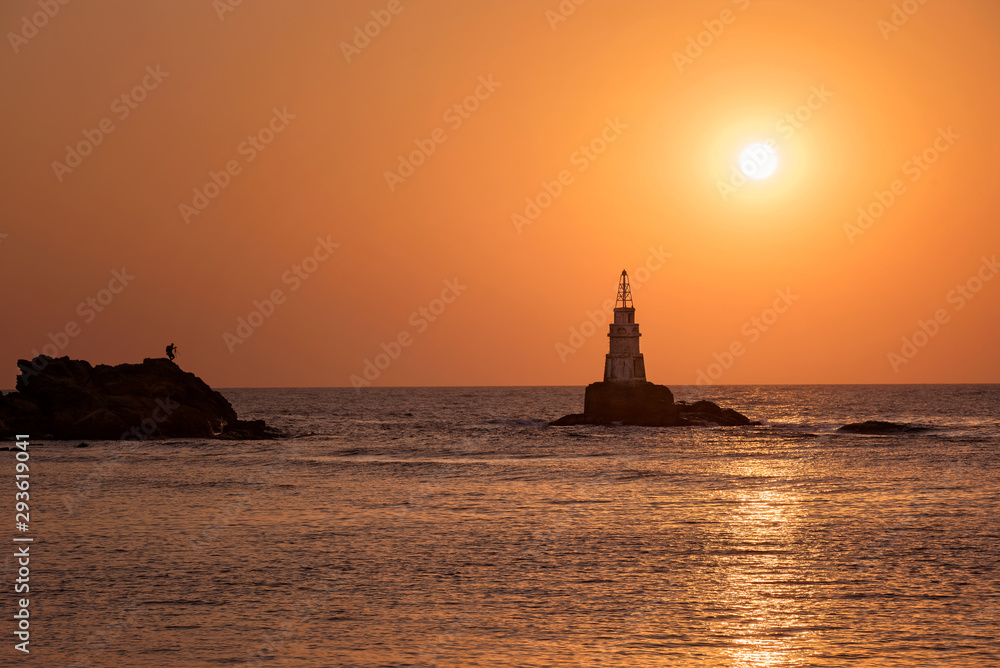 Photographer shooting beautiful sunrise. Landscape from the Black Sea, Bulgaria, Ahtopol lighthouse.