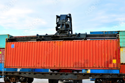 Shipping container loading by richtracker on the freight rail car at logistic warehouse port. Ocean Freight Cargo Shipping, Intermodal Container Freight concept - Image photo