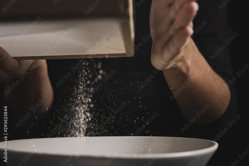 Close-up view hand sifting flour