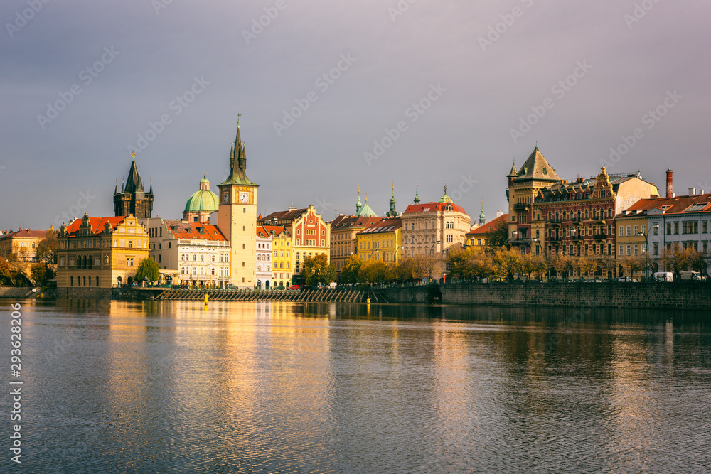 Prague Old Town on the banks of Vltava river, scenic cityscape in sunset light with reflection in the water, Czech Republic, travel background