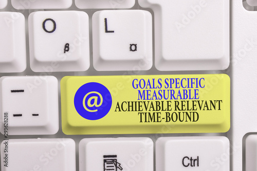 Writing note showing Goals Specif Measureable AC. Business concept for Goals Specific Measurable Achievable Relevant Time Bound White pc keyboard with note paper above the white background photo