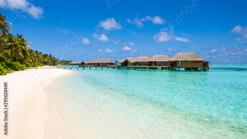 Beautiful sandy beach and over water tropical bungalo