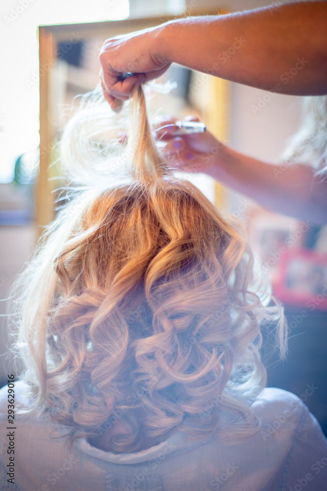 Fototapeta premium Frau wird zu Hause von Ihrer Friseurin für die Hochzeit gestyled
