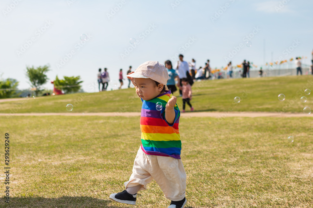 Asian cute baby playing on the grass in the spring