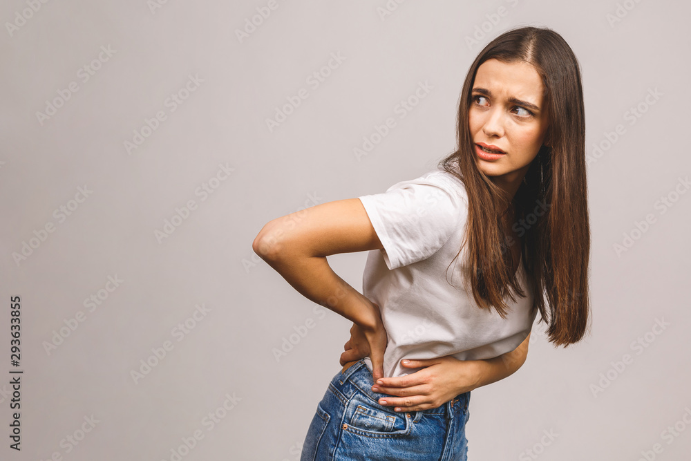 Unhappy woman suffering from backache isolated over grey background. Unhappy woman suffering from backache isolated over grey background.