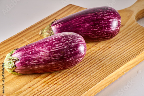 Gros plan sur duo d'aubergine violette striées de blanc, sur une planche en bois photo