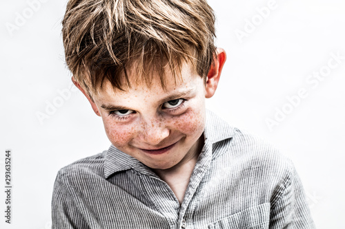 playful boy smiling, looking mischievous for shy child humour photo