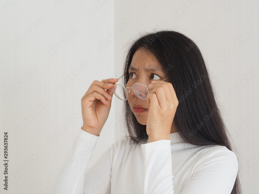 strabismus or crossed eye and amblyopia and diplopia in asian woman with hold glasses. Cause of a failure of the two eyes strabismus or crossed eye and amblyopia and diplopia in asian woman with hold glasses. Cause of a failure of the two eyes