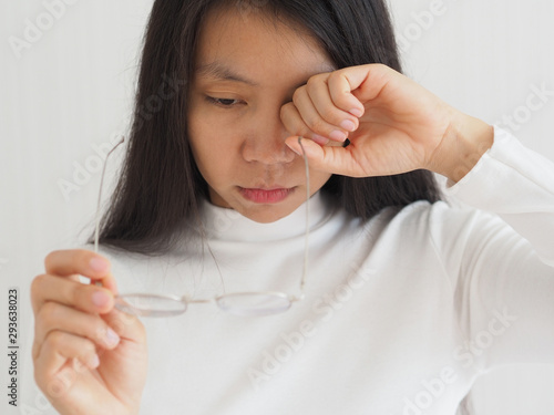diabetic retinopathy in asian women and she is touching eye, symptoms of blurred vision and eye floaters or transparent and colorless spots.. photo