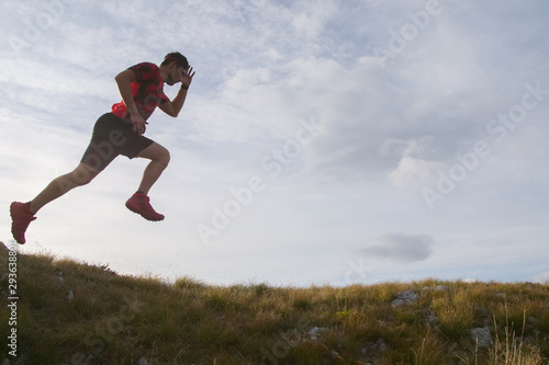Trail running man jumping in the sky