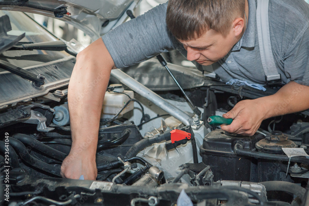 Car repair and cleaning concept - car engine close-up, wiping parts under the hood Car repair and cleaning concept - car engine close-up, wiping parts under the hood