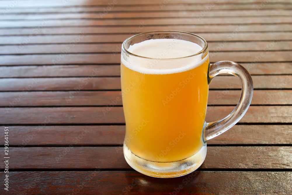 ein volles Glas mit Bier steht auf einem Tisch ein volles Glas mit Bier steht auf einem Tisch