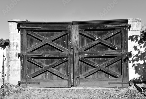 Old countryside wooden gate with with stone columns in vintage style in black and white