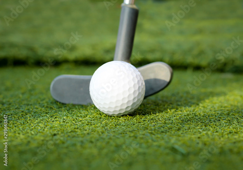 Golfball und Putter einer Minigolfanlage