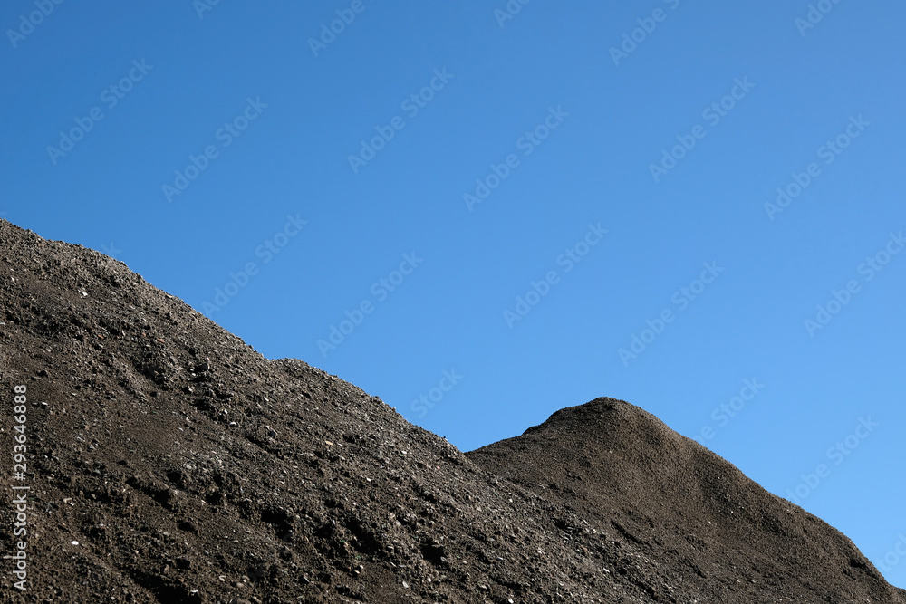 Barren mountain ridge and blue sky background