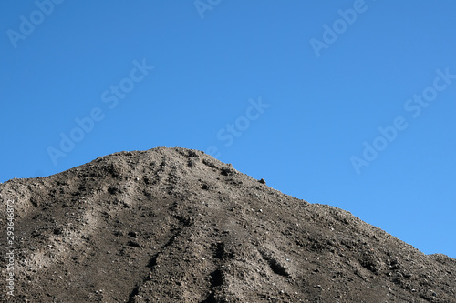 Pile of grey ash material blue sky background