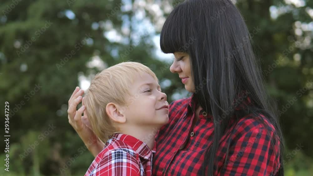 happy family mom and son concept . mom tender childhood video . slow motion video . mom a brunette lifestyle girl gently hugs takes care of the boy son blonde outdoors happy family mom and son concept . mom tender childhood video . slow motion video . mom a brunette lifestyle girl gently hugs takes care of the boy son blonde outdoors