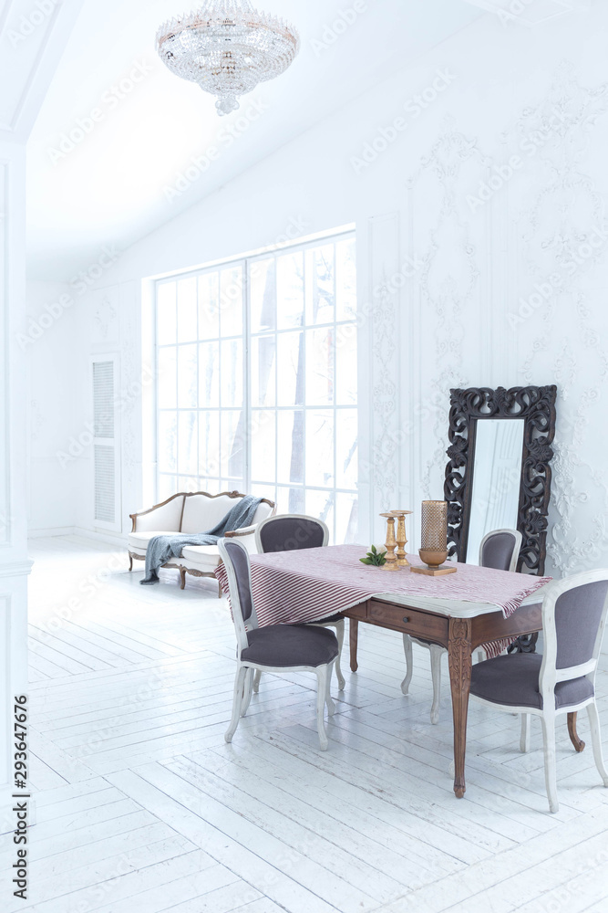 Fototapeta premium A spacious bright living room with a stylish modern design with elements of antique decor and beautiful chic furniture