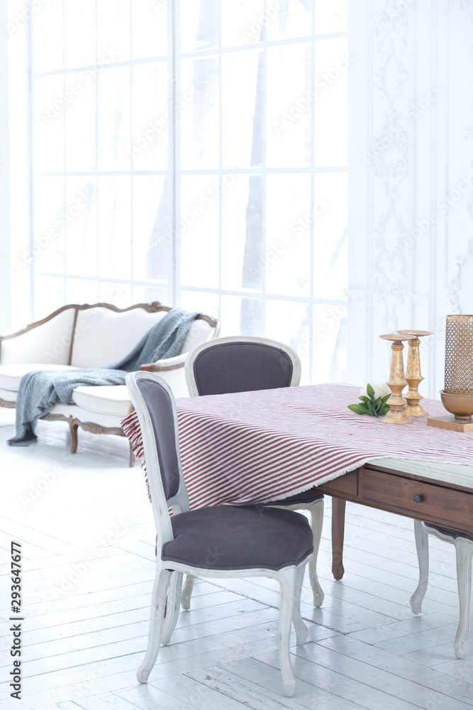 A spacious bright living room with a stylish modern design with elements of antique decor and beautiful chic furniture A spacious bright living room with a stylish modern design with elements of antique decor and beautiful chic furniture
