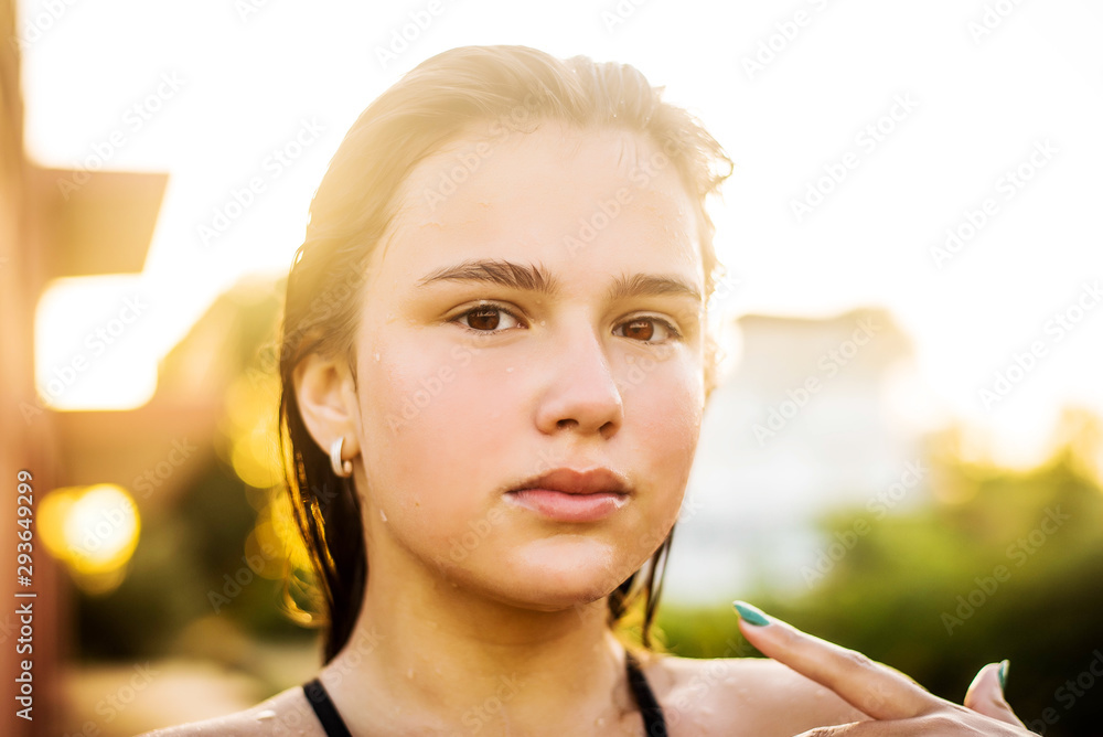 Beautiful young woman with clean perfect skin and wet hair. Portrait of beauty model with natural makeup moisturizing her skin. Spa, skincare and wellness. Lifestyle resort concept/ Sunny Beautiful young woman with clean perfect skin and wet hair. Portrait of beauty model with natural makeup moisturizing her skin. Spa, skincare and wellness. Lifestyle resort concept/ Sunny