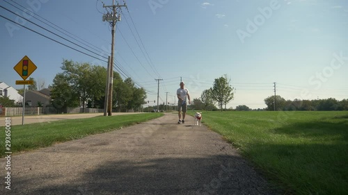 Wallpaper Mural Man walking a white dog on a path on a sunny, warm, summer day. Torontodigital.ca