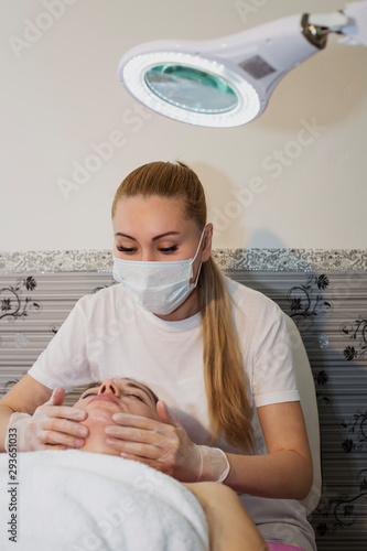 Young woman receiving facial epilation close up. Cosmetologist removes hair on face. Beauty salon, mustache depilation