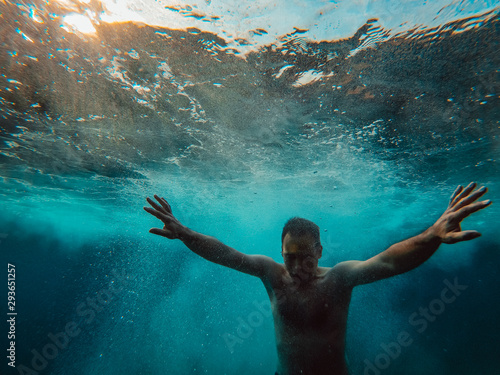 Billede på lærred Underwater photo of man emerging from the water