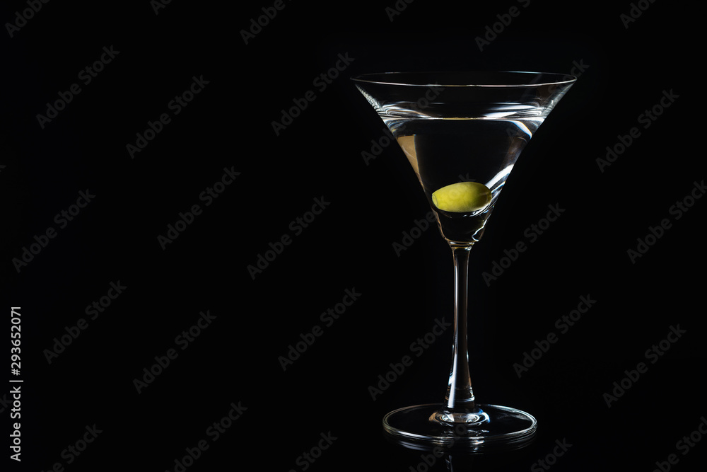 Martini glass and olives on a black background. Selective focus. Close up.