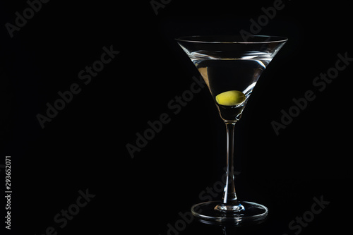 Martini glass and olives on a black background. Selective focus. Close up.