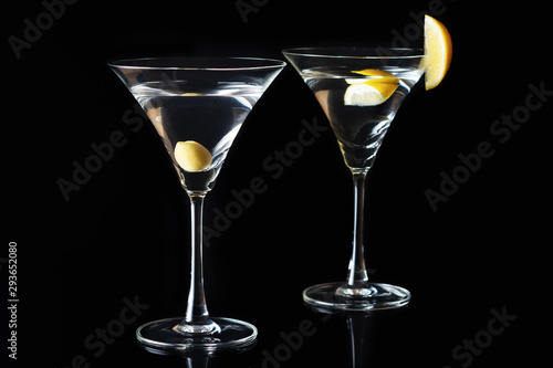 Martini Glasses with olive and lemon piece on a black background. Selective focus.