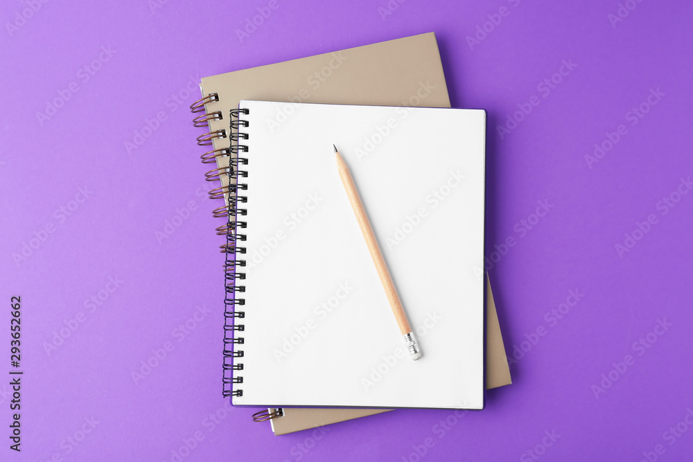 Notebooks with pencil on purple background, top view Notebooks with pencil on purple background, top view