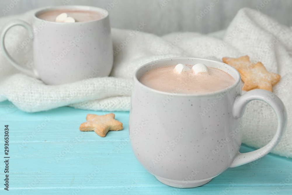 Composition with delicious cacao drink in cup and blanket on turquoise wooden background Composition with delicious cacao drink in cup and blanket on turquoise wooden background