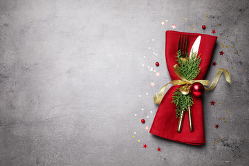 Cutlery set on grey table, top view with space for text. Christmas celebration