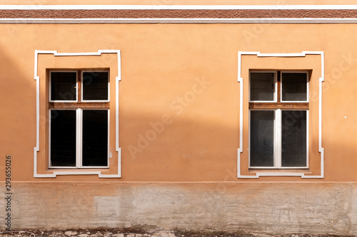 two windows on a yellow wall in romania