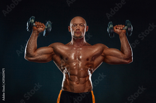 Strong and fit man bodybuilder. Sporty muscular guy with dumbbells. Sport and fitness motivation. Individual sports recreation. © Mike Orlov