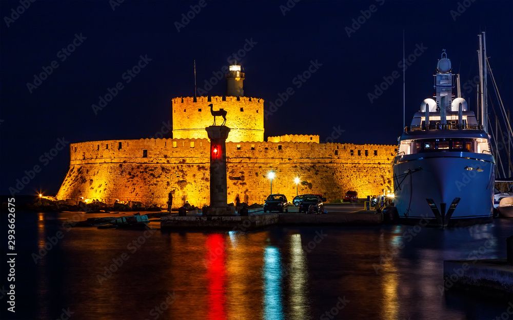Tower of St. Nicholas in Rhodes Greece by night - Bluelight. Motion blur on greek flag and sail masts. Original colors.
