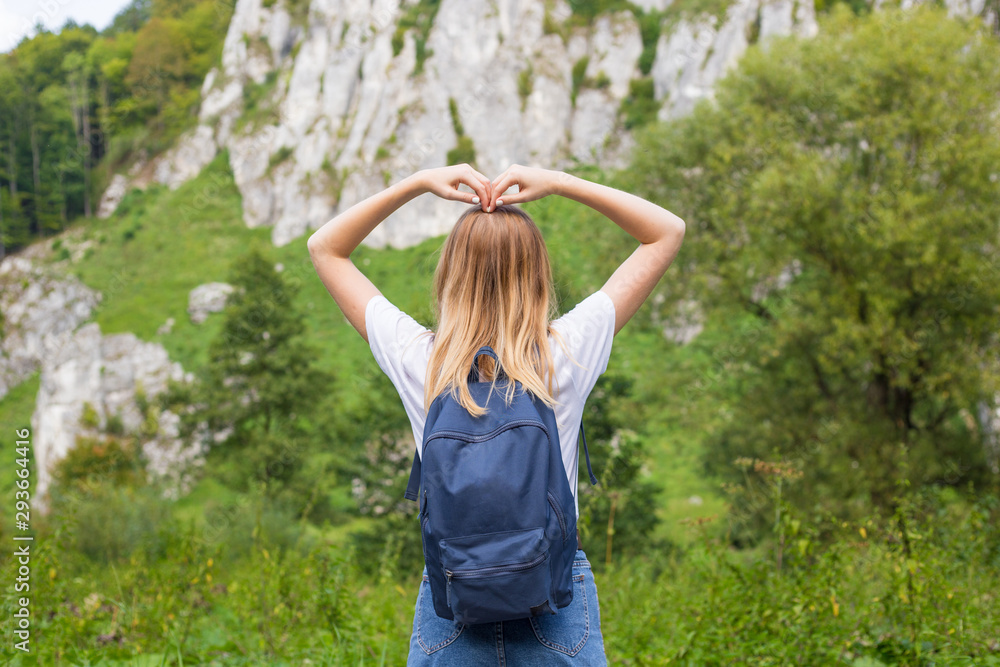 Girls hand to make a heart shape. Copyspace. A young pretty blonde woman standing on a mountains. Girls hand to make a heart shape. Copyspace. A young pretty blonde woman standing on a mountains.