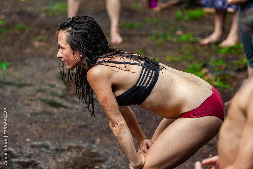 Stockfoto Diverse people enjoy spiritual gathering A young caucasian woman  wearing underwear is seen from the side, standing in mud as people  experience multicultural rituals in nature. | Adobe Stock