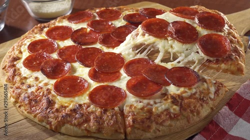 A slice of pepperoni pizza being served.