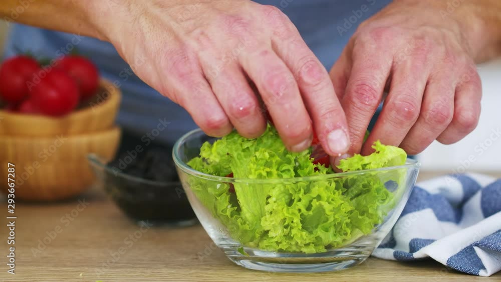 Mans hans preparing fresh vegetable salad in his kitchen. Slow motion video shot on Black Magic Cinema camera 6K on RAW format Mans hans preparing fresh vegetable salad in his kitchen. Slow motion video shot on Black Magic Cinema camera 6K on RAW format
