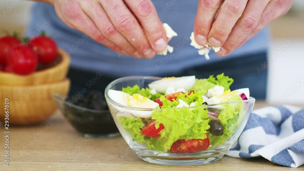 Mature man preparing fresh vegetable salad in his kitchen. Slow motion video shot on Black Magic Cinema camera 6K on RAW format Mature man preparing fresh vegetable salad in his kitchen. Slow motion video shot on Black Magic Cinema camera 6K on RAW format