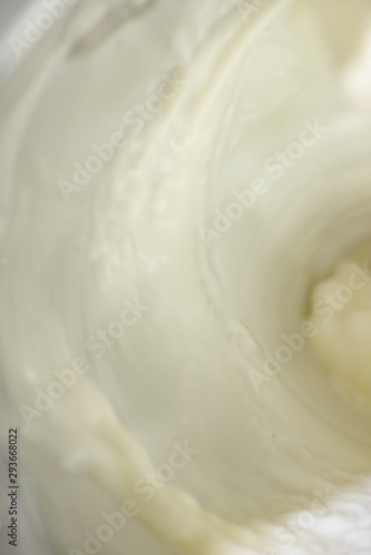 Vertical background with flowing white milk, soft focus