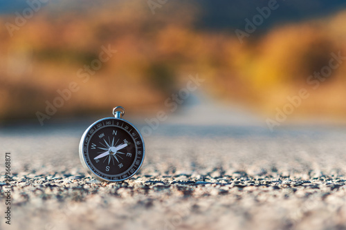 Compass on the road in the mountains, during sunset, in the autumn.