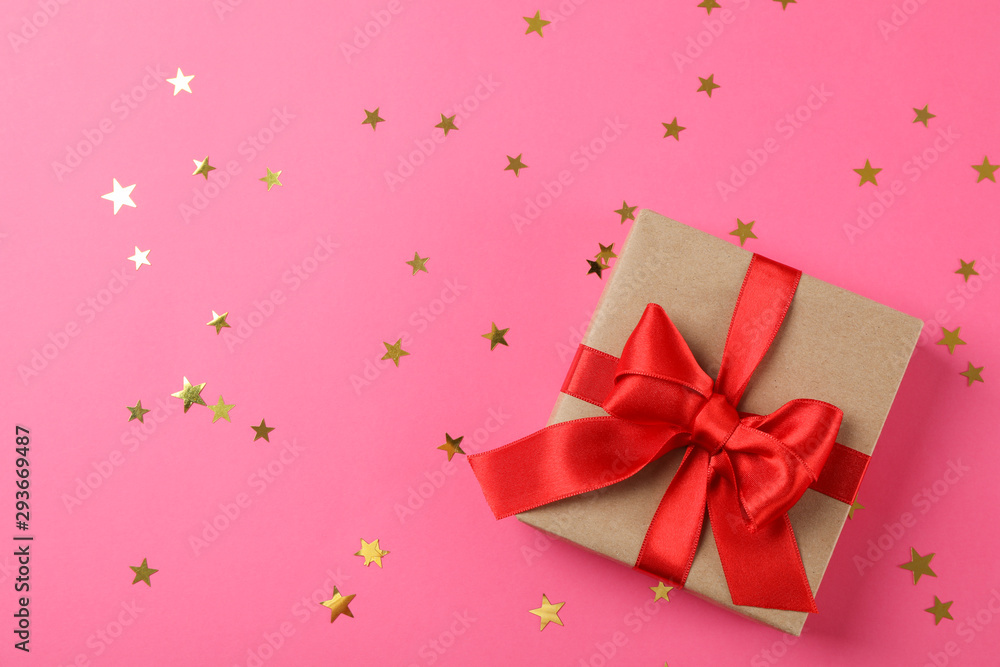 Gift box with bow on decorated pink background, space for text