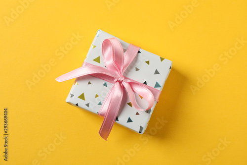 Gift box with bow on yellow background, space for text © Atlas