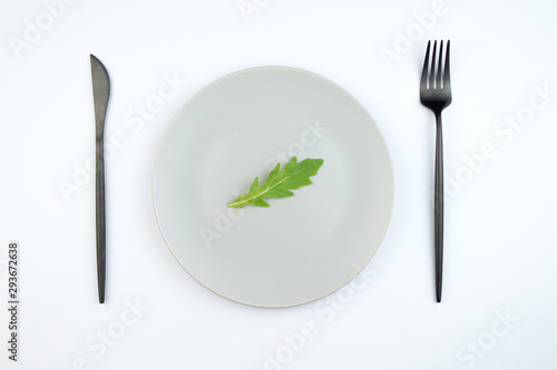 Arugula leaves on a gray plate. The concept of proper and dietary nutrition.