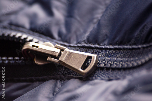 Zipper slider on. Buttoning and unfastening clothes. Close-up, selective focus.