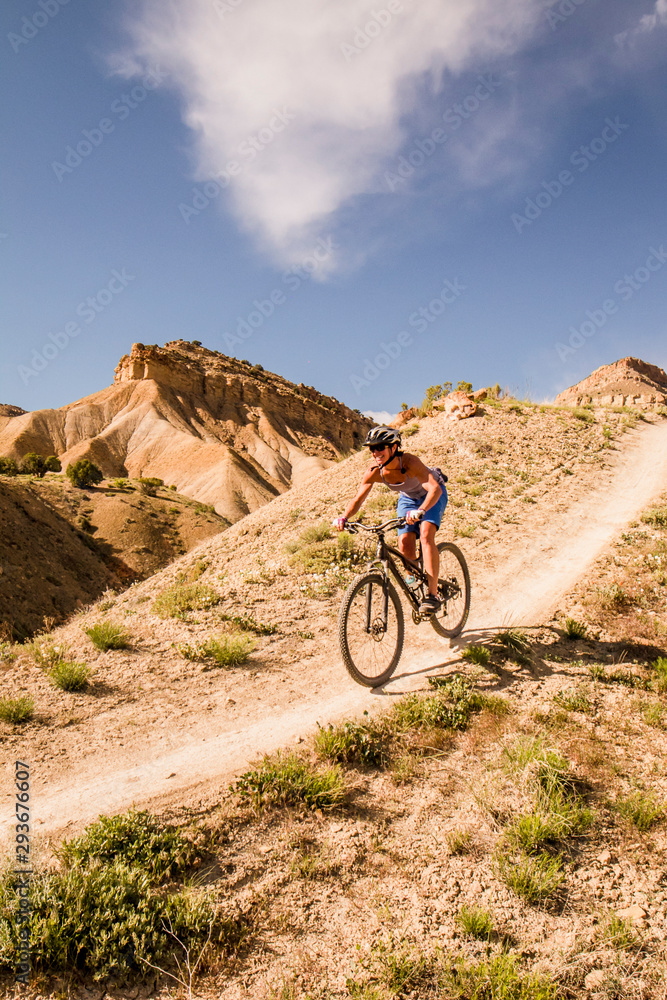 One woman enjoys the warm spring weather mountain biking on the North Fruita Desert Trails outside of Grand Junction, Colorado. One woman enjoys the warm spring weather mountain biking on the North Fruita Desert Trails outside of Grand Junction, Colorado.