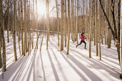 One woman trail running through an aspen forest in Frisco, Colorado.