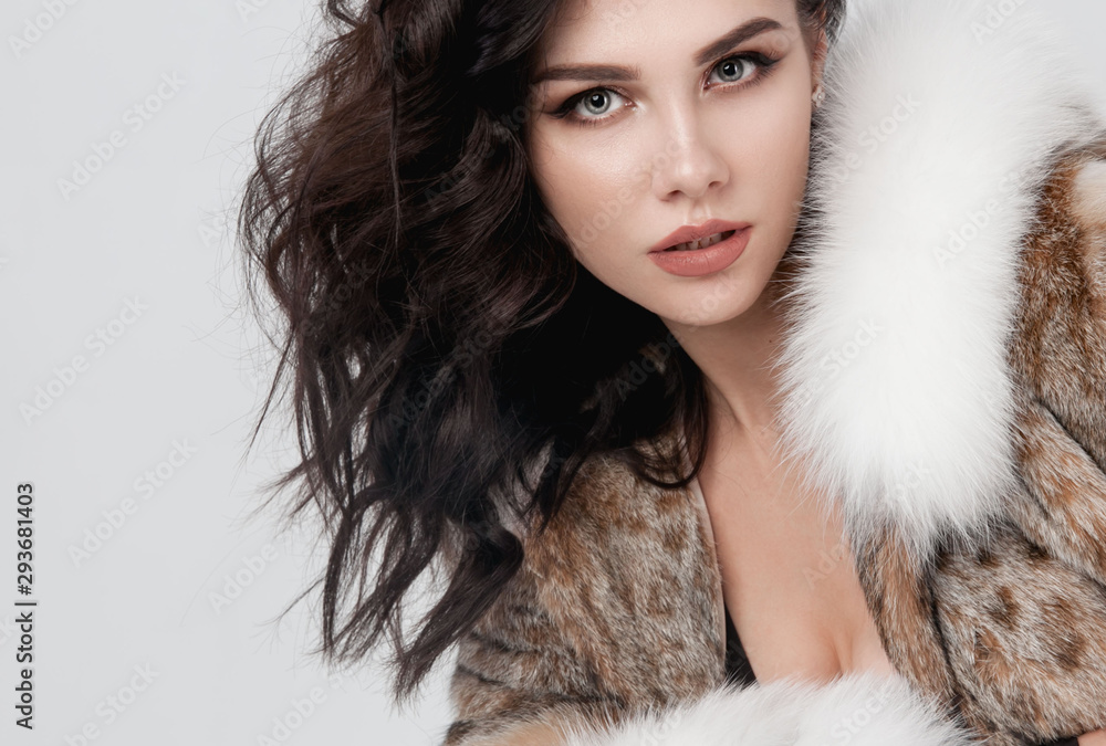 Beautiful elegant woman posing in luxury fashion fur coat over white background. Winter clother.